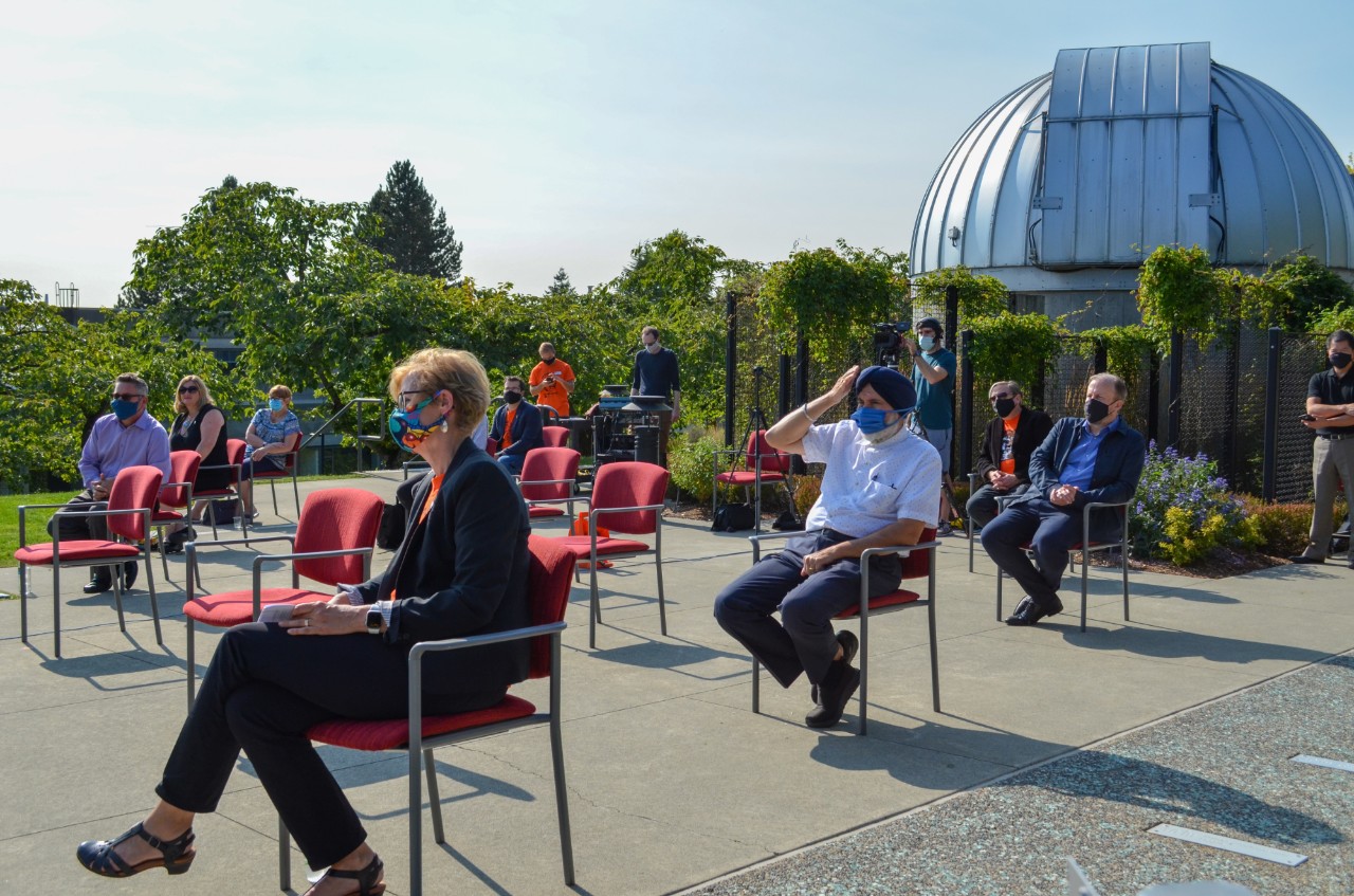 A socially distanced audience of campus partners in front of Trottier Observatory