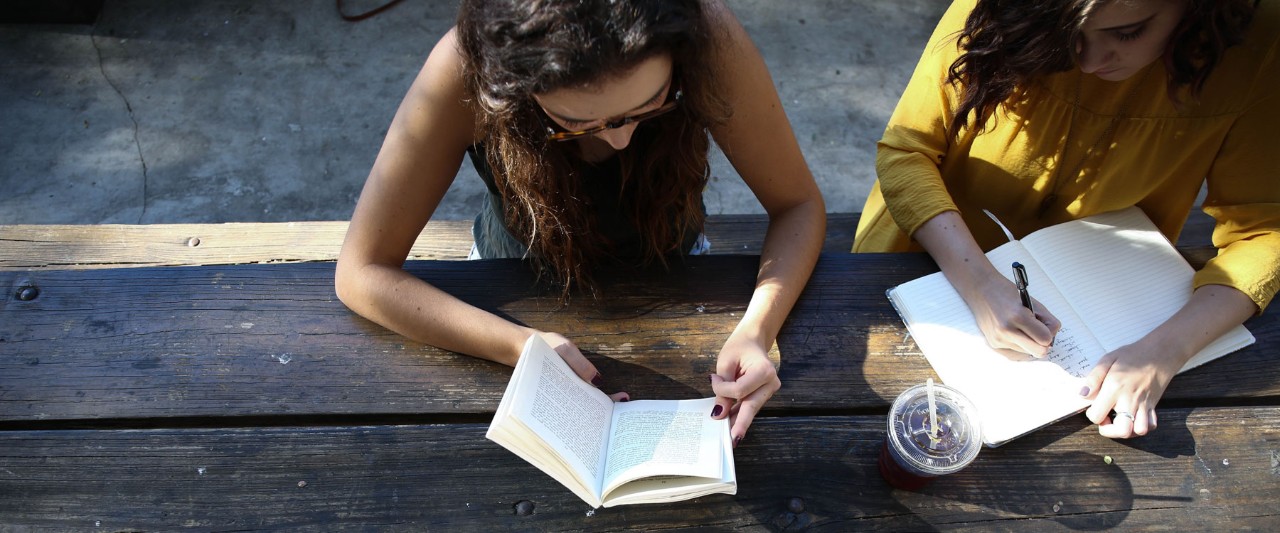 2 students writing on a table