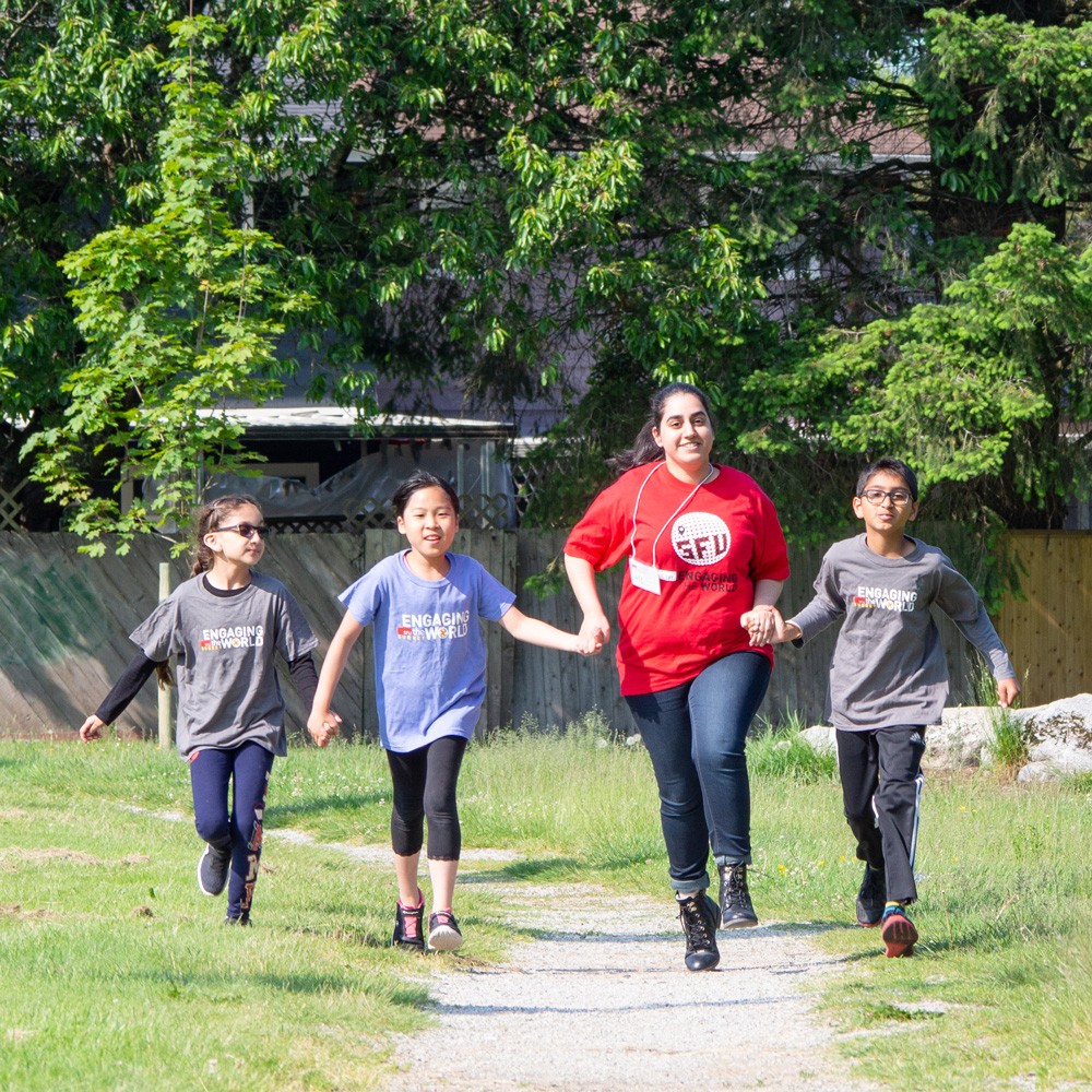 Volunteer playing with children running outdoor