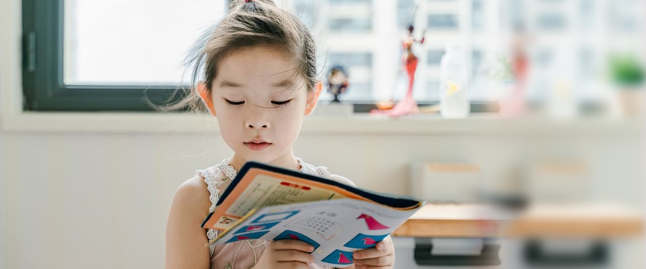 Little girl looking at a book