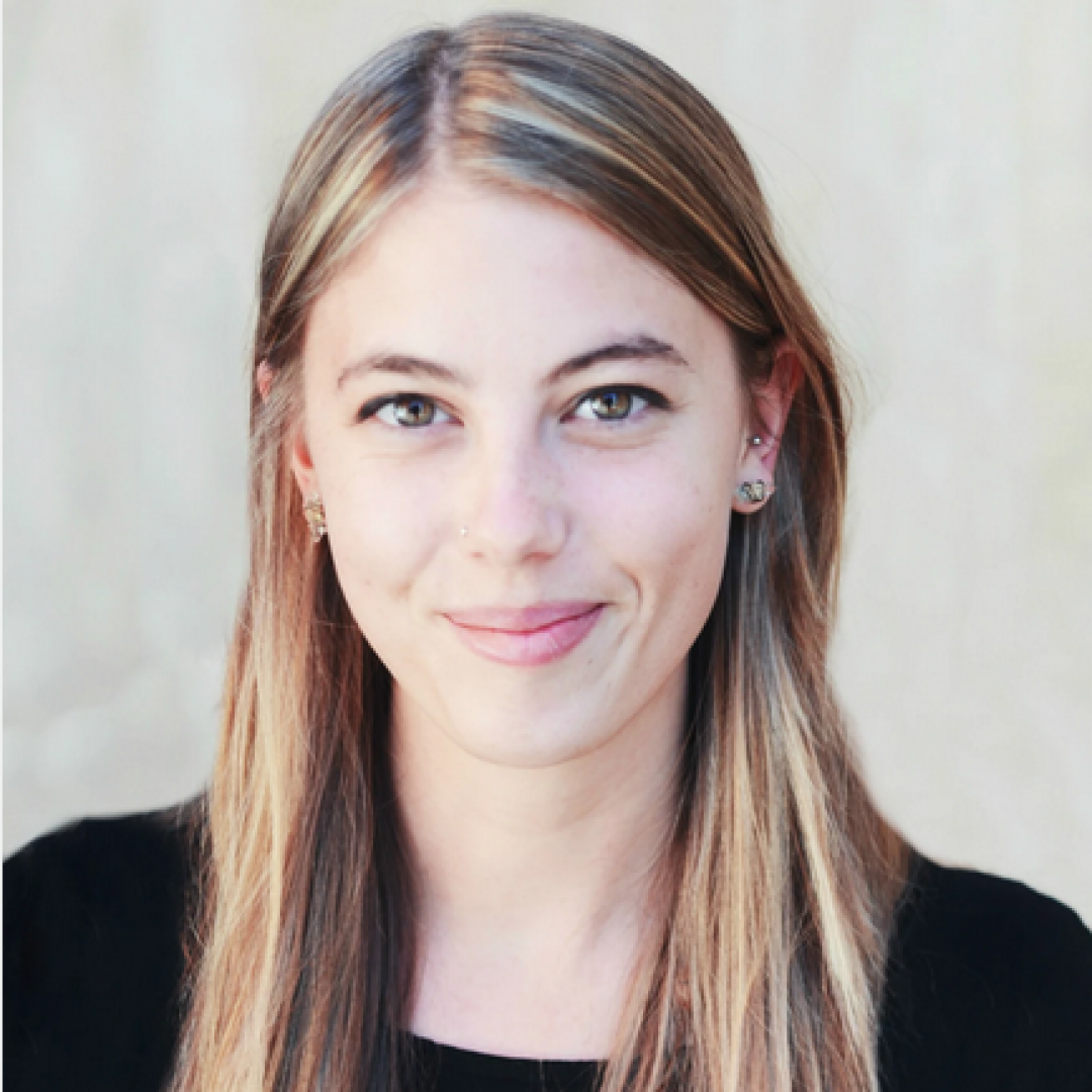 Photo headshot of Skye smiling with grey backdrop