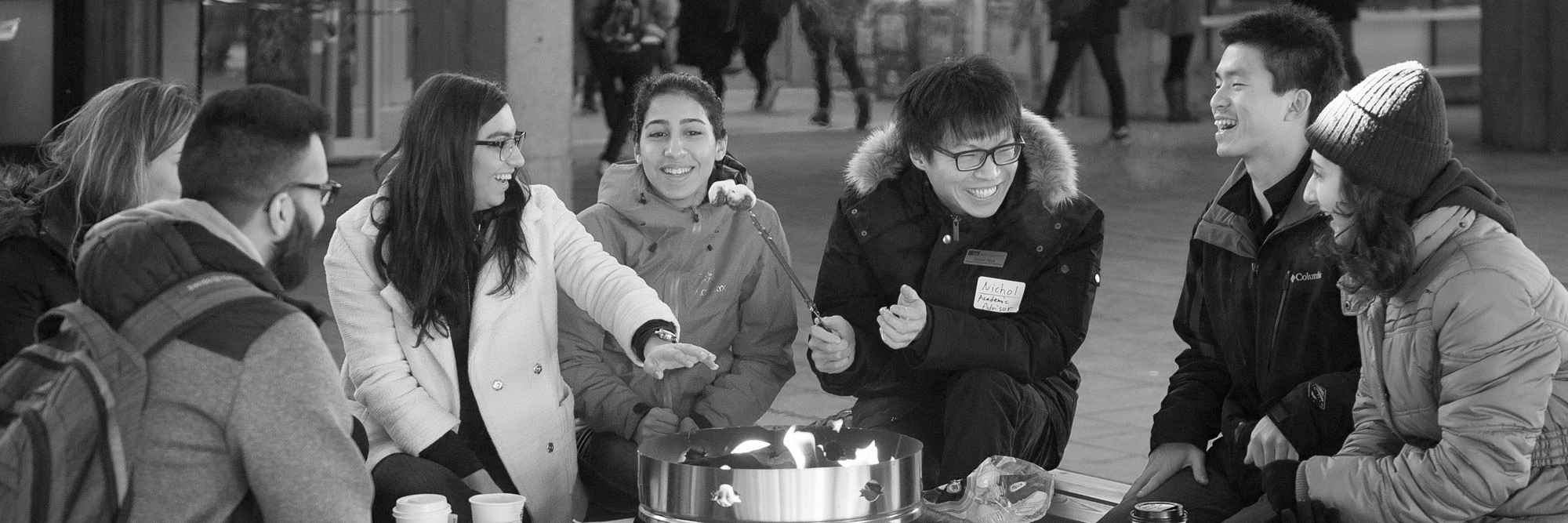 SFU students sitting around a firepit in Convocation Mall.
