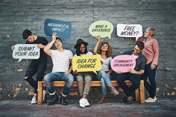 Students holding speech bubbles about community engagement