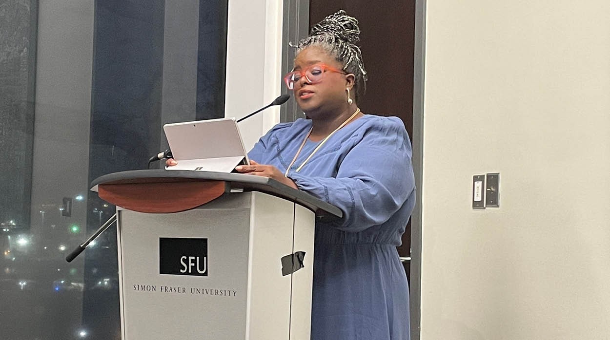 Junie Désil reading at a podium