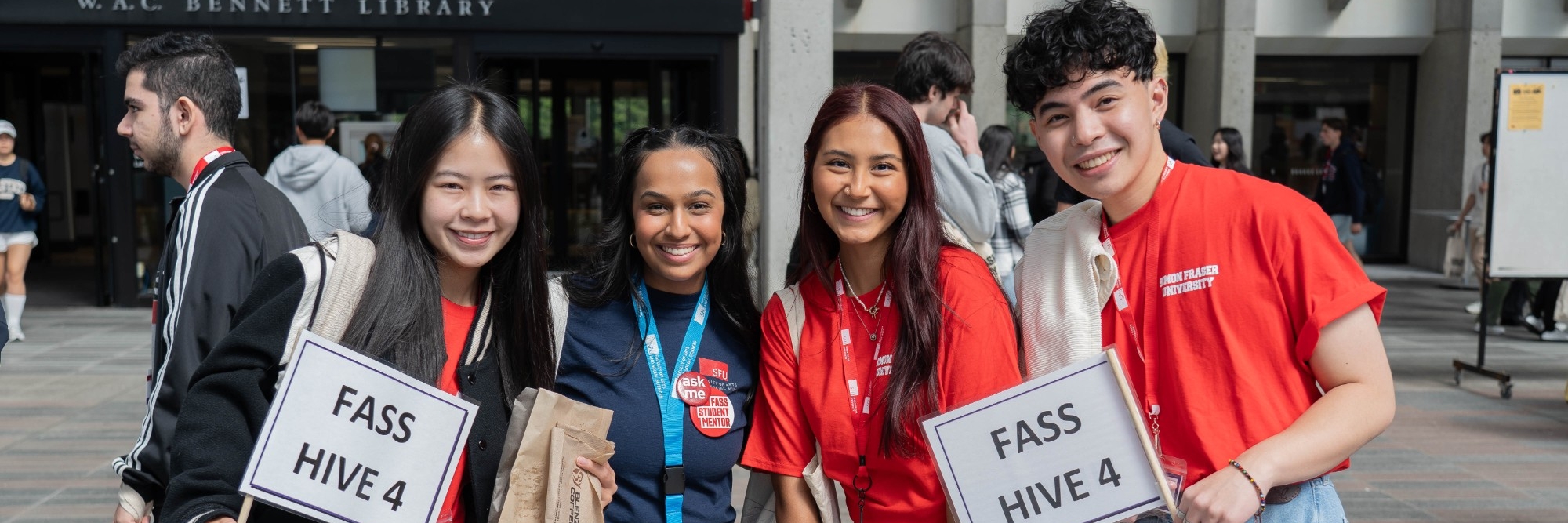 Four FASS Hive Leaders photographed in front of the WAC Bennett Library at SFU Burnaby Campus.