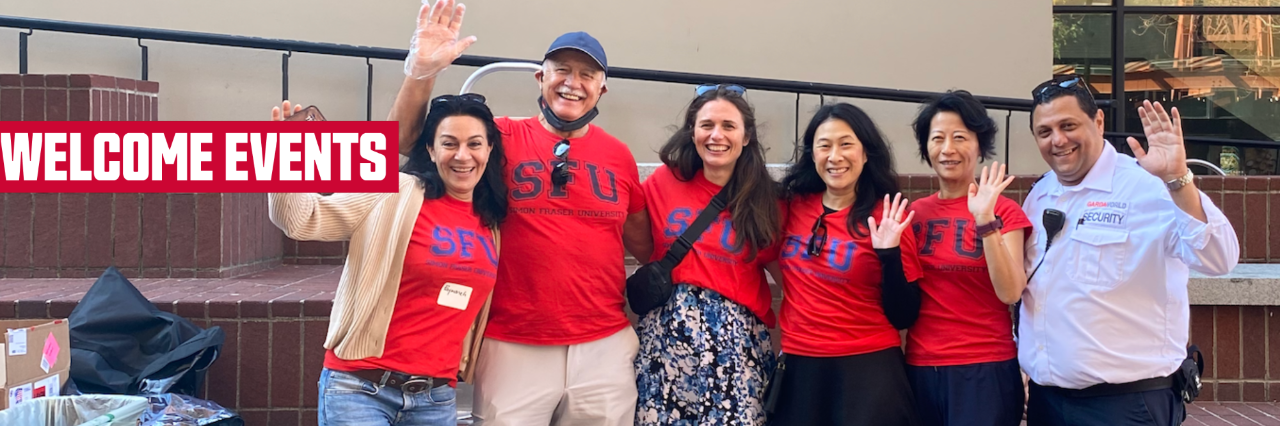 A group of staff members, most wearing red SFU t-shirts, smiling and waving at the 2023 SFU Vancouver Welcome Back Community BBQ