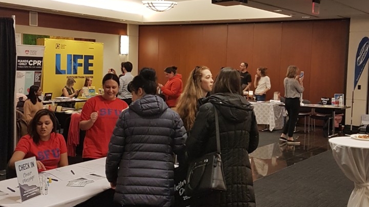 Vendors set up indoors with people visiting the various vendors' tables as part of February 2020 Wellness Day
