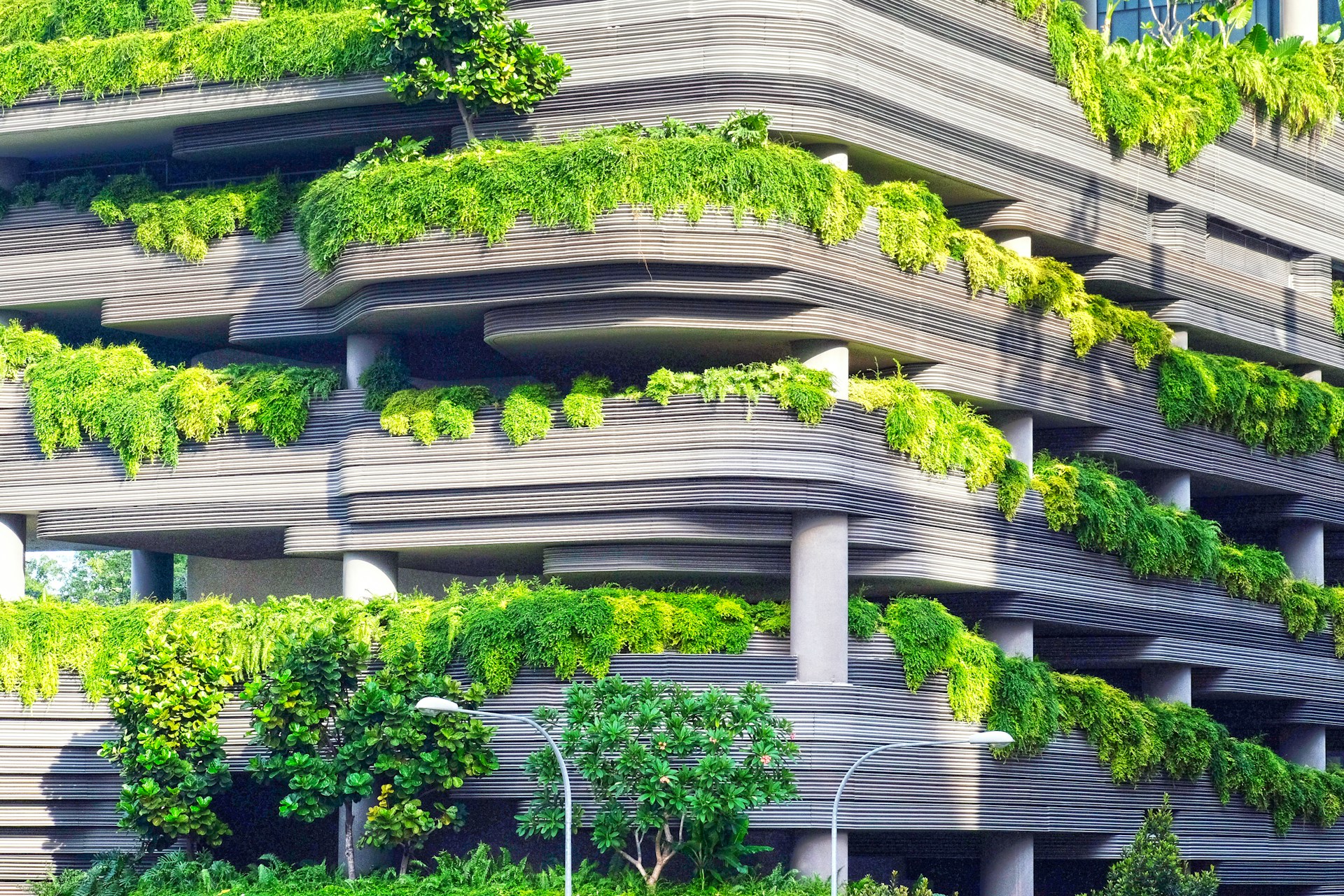 building with many ledges and green overgrown plants