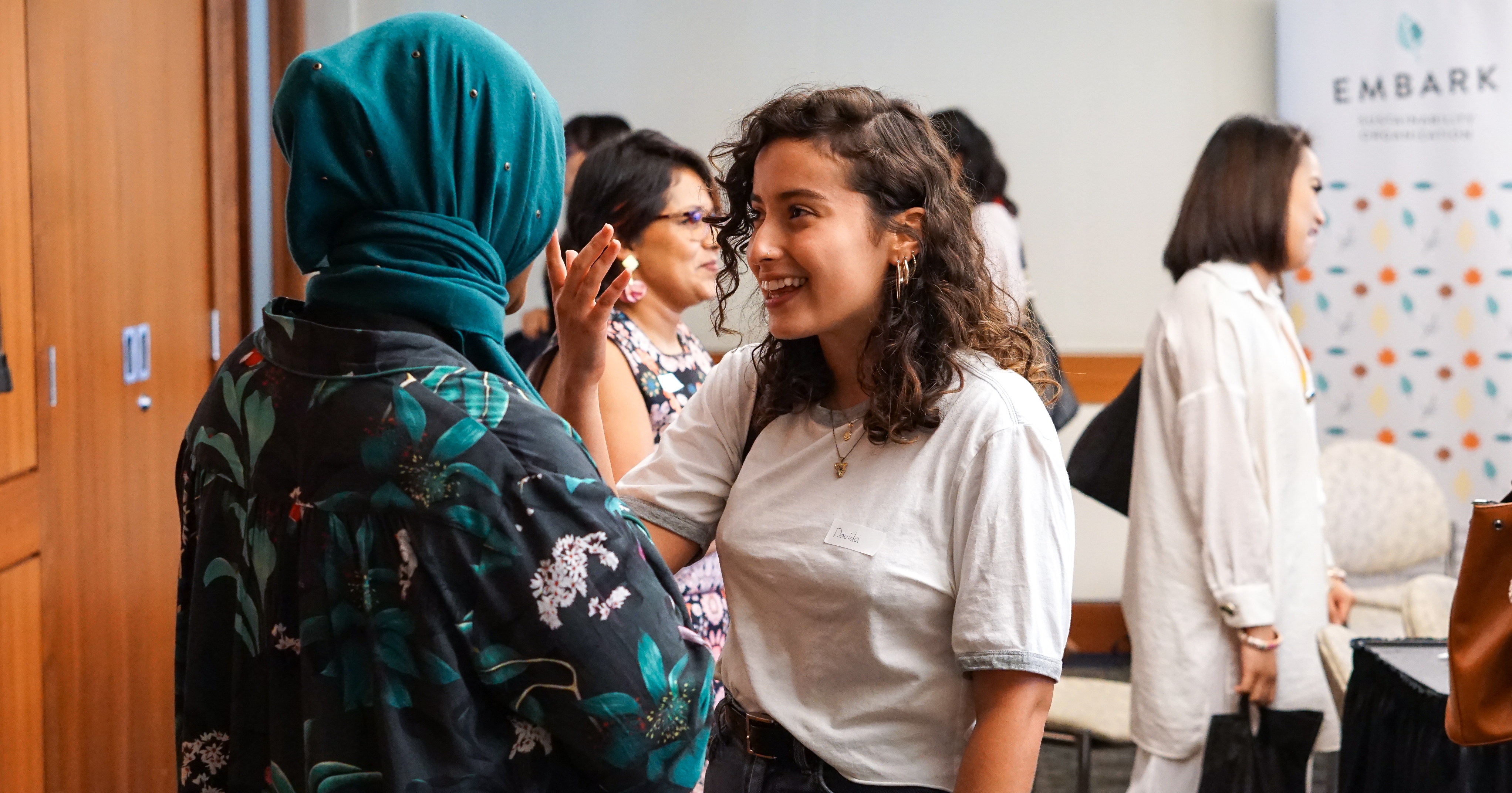 Two woman chatting in a room.