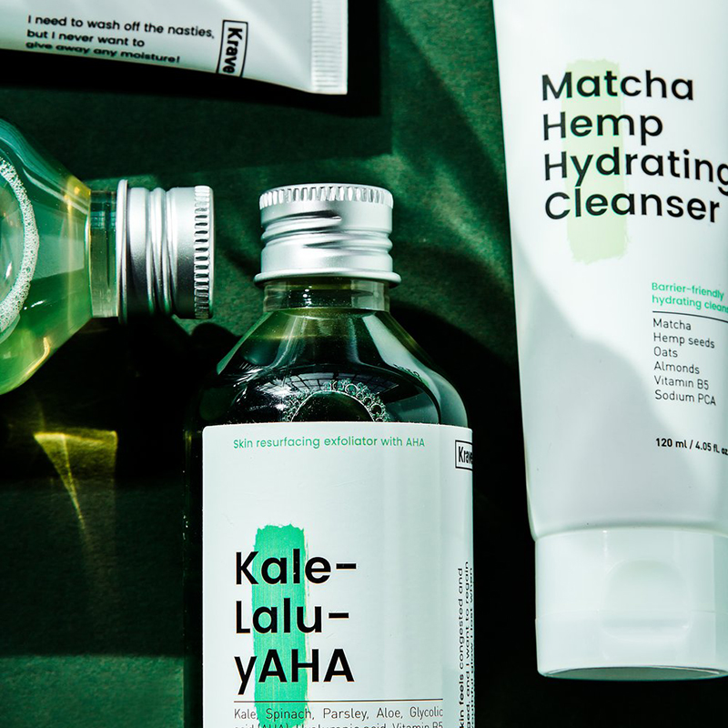 Kale-lalu-yAHA and Matcha cleanser laying down on a green background