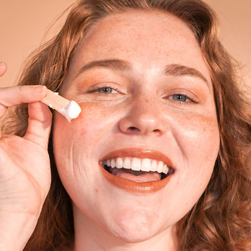 A women about to put Oat Cream on her face