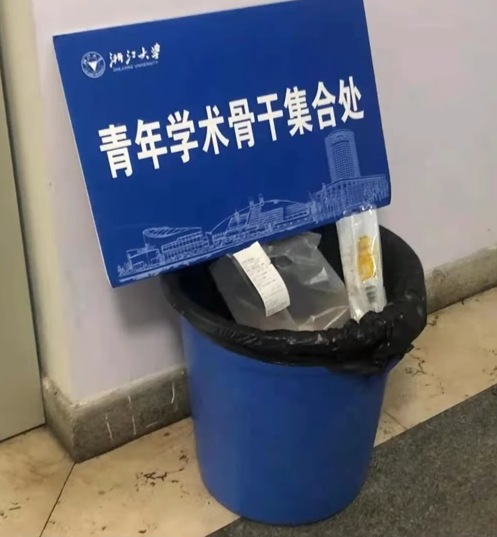 second posted image, showing a garbage can with a sign on it saying 'assembly area for young academic backbones' 