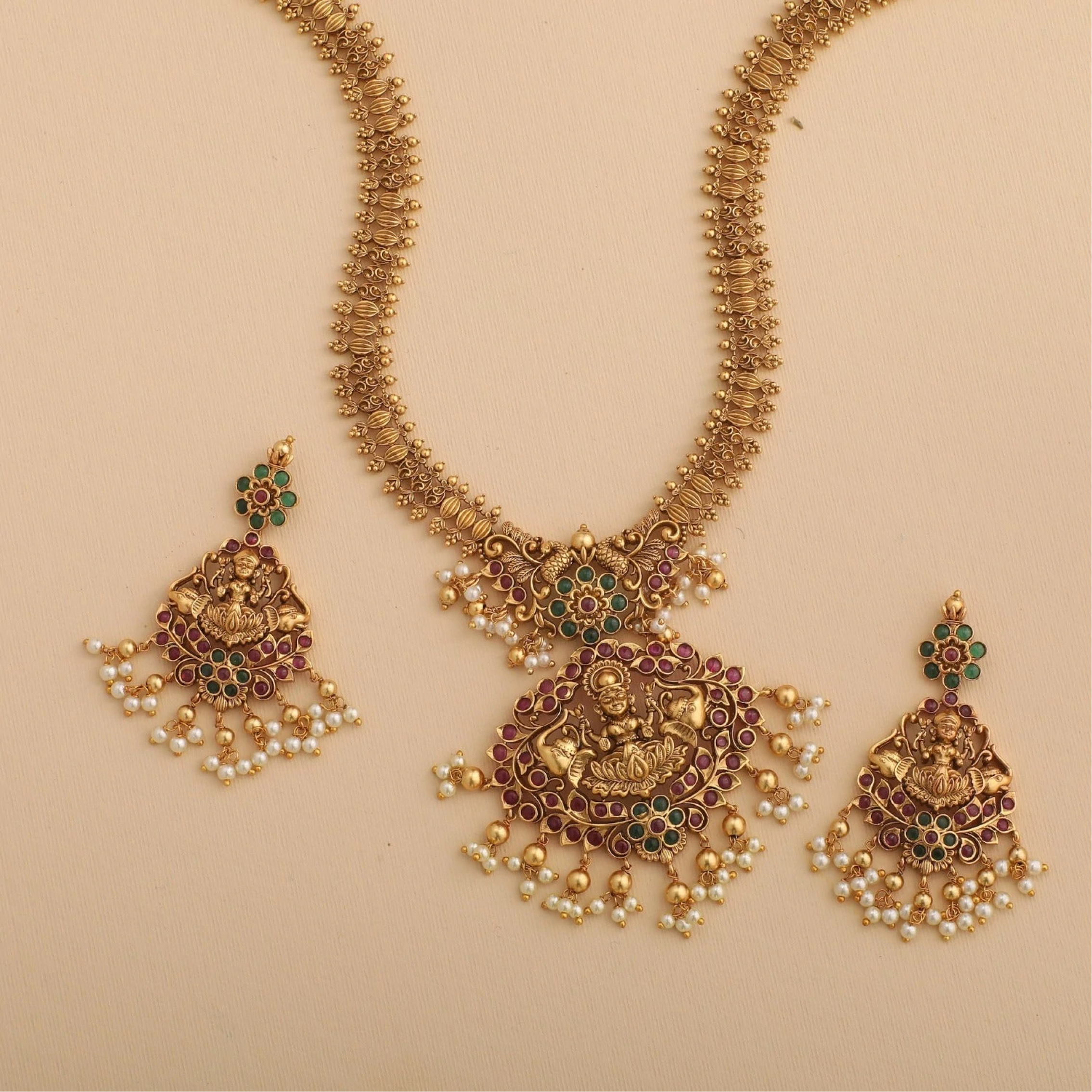 a matching long gold necklace and stud earrings with pearls