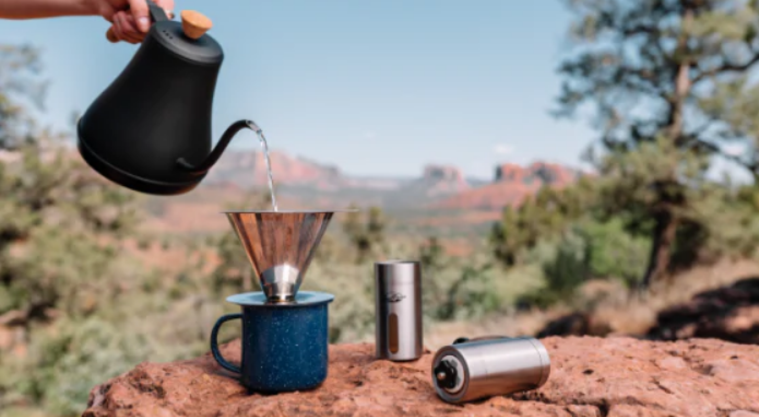 wide image of coffee being poured into cup in the outdoors