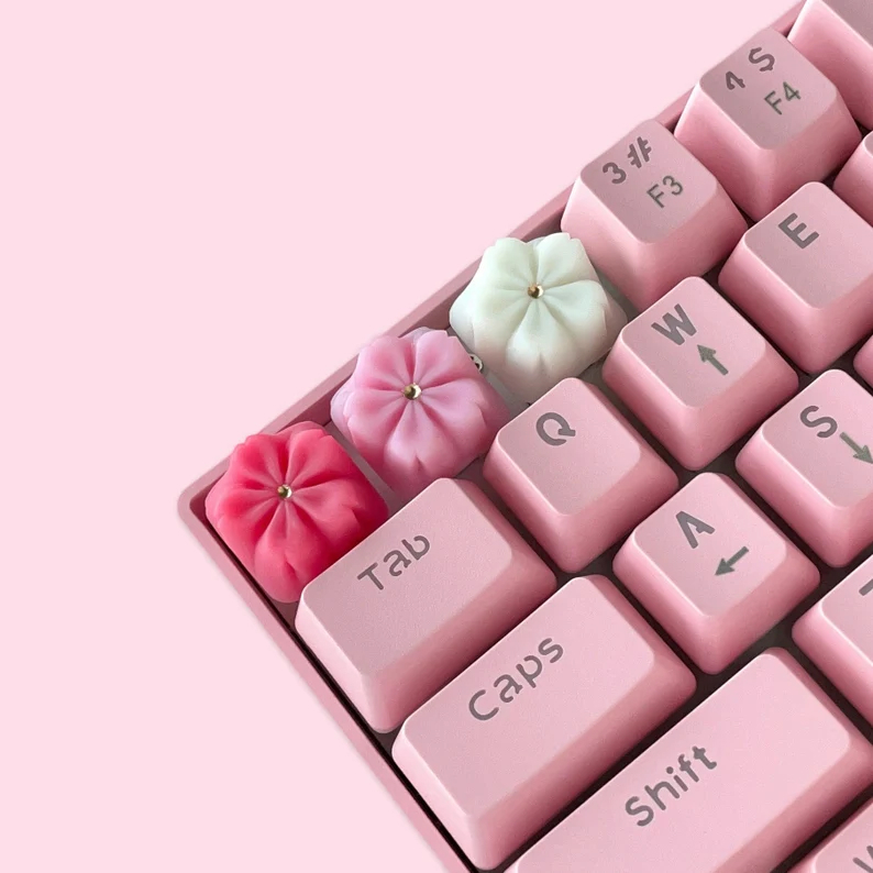 3 sakura shaped keycaps in red, pink and white