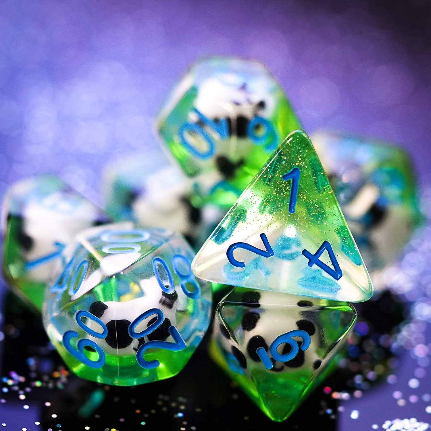 7 Translucent resin dice with a panda figure inside on a glittering surface