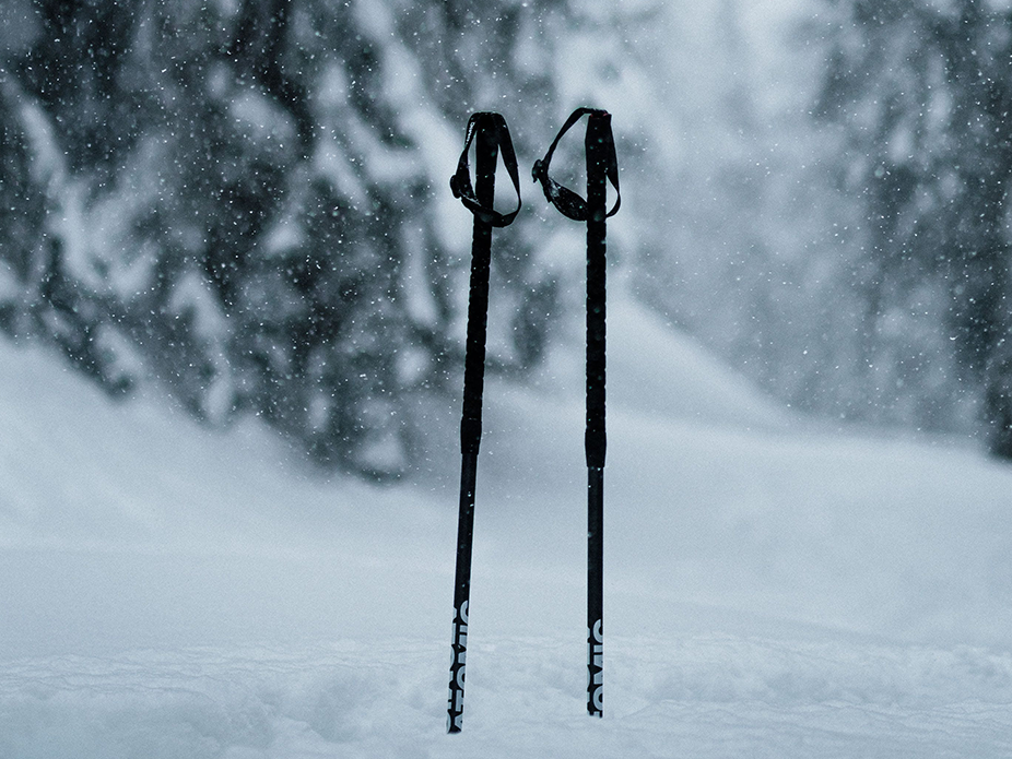 Atomic skis black with white texts stuck in snow