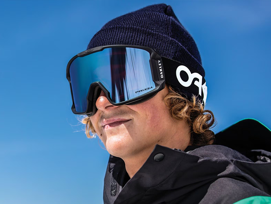 oakley black goggles with blue glass (that is reflective) being worn in the sun by a man with black beenie