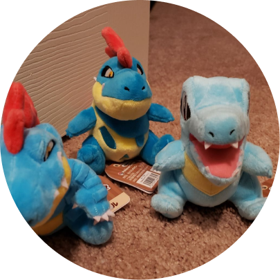 Review image of Sitting Cuties Totodile plush with its 2 other evolution plushies on the carpet