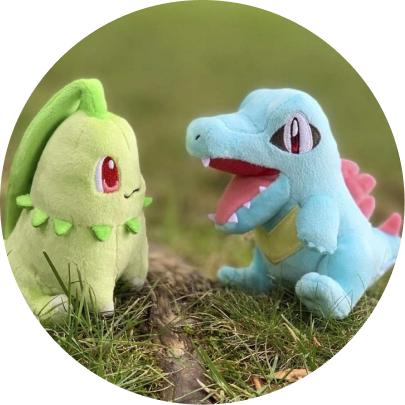 Review image of Sitting Cuties Totodile beside a Chikorita plush on grass