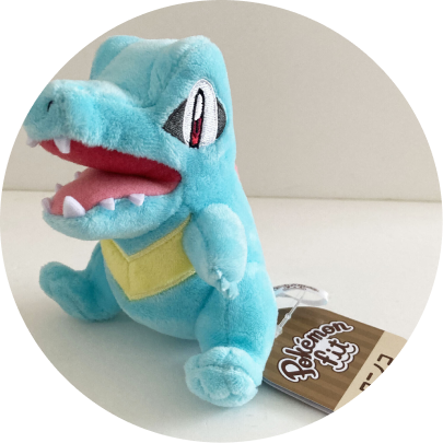 Review image of Sitting Cuties Totodile plush sitting on a wood table against a white wall