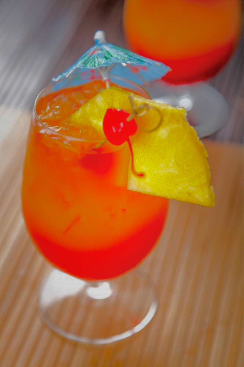 Bahama Mama: a red drink with a Pineapple slice and a cherry as garnish