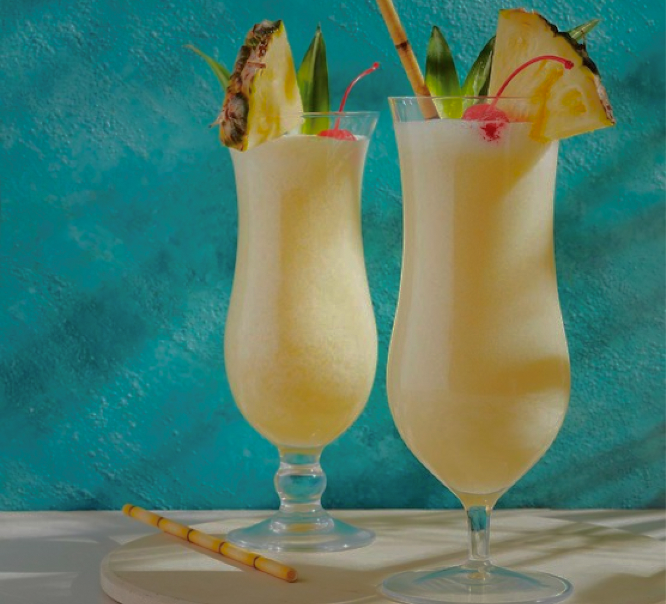 Pina Colada: a white drink with Pineapple and cherry garnishes