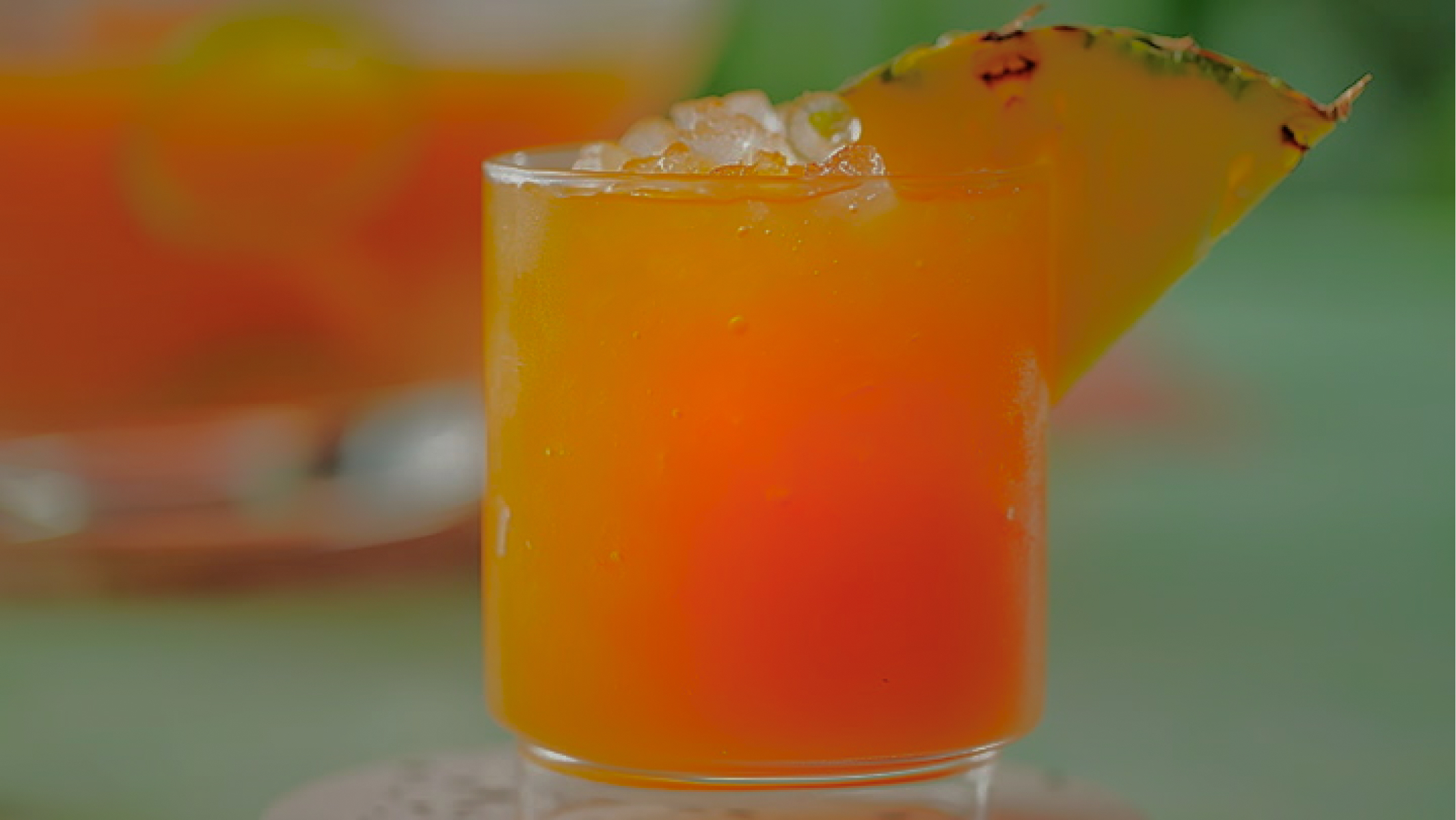 Rum Punch: a orange drink with ice and a pineapple garnish