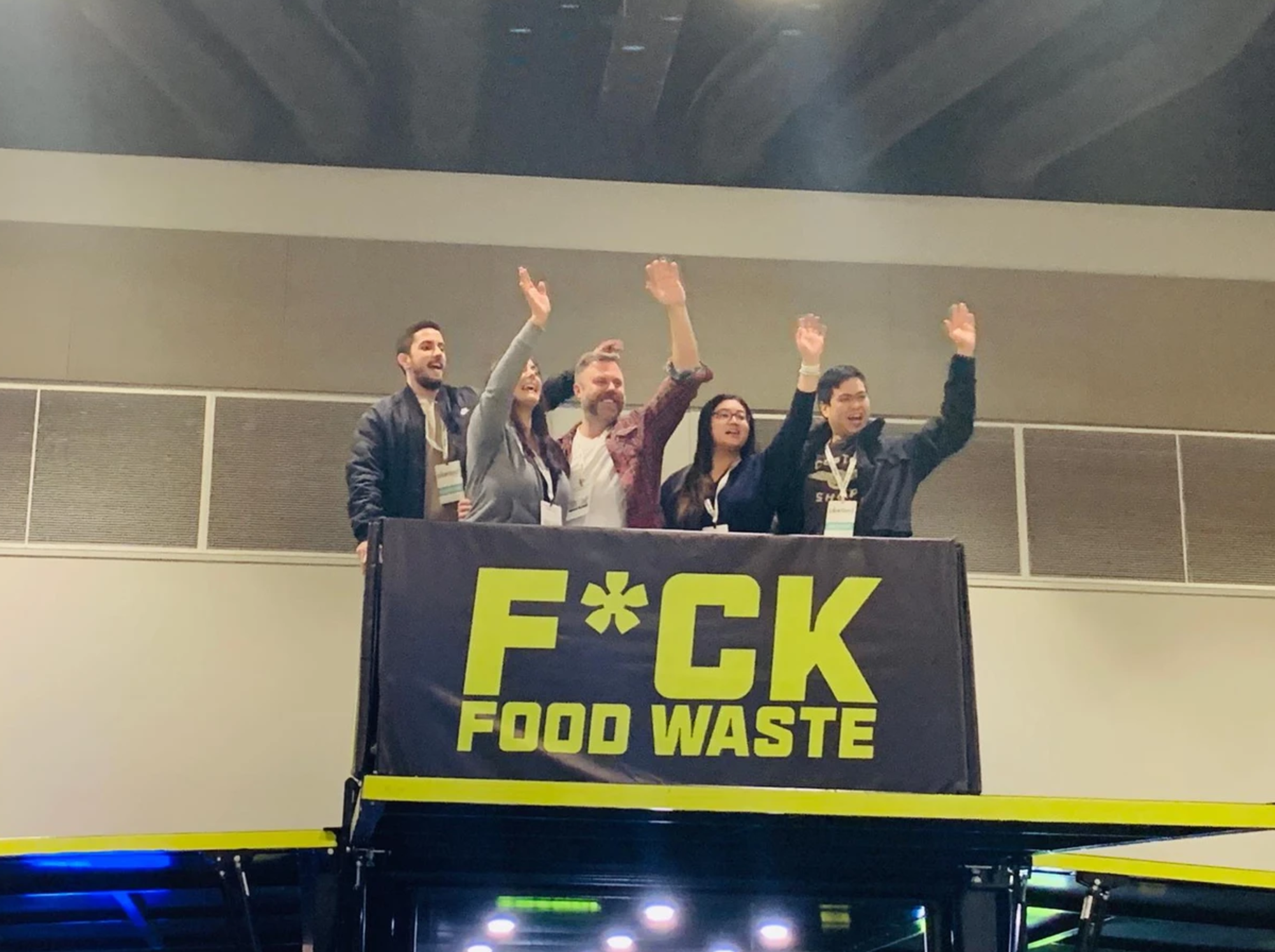 5 people waving at on top of the Trendi tradeshow booth