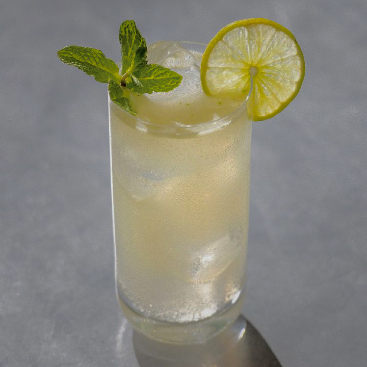 Mojito: a white drink with a slice of lime and mint as garnishes