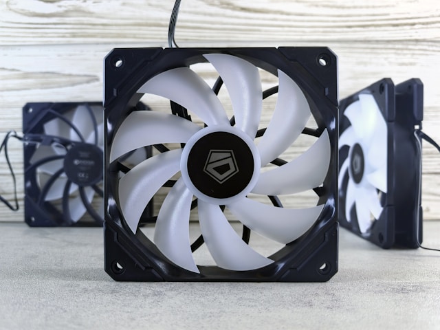 >A black and white fan sitting on top of a table