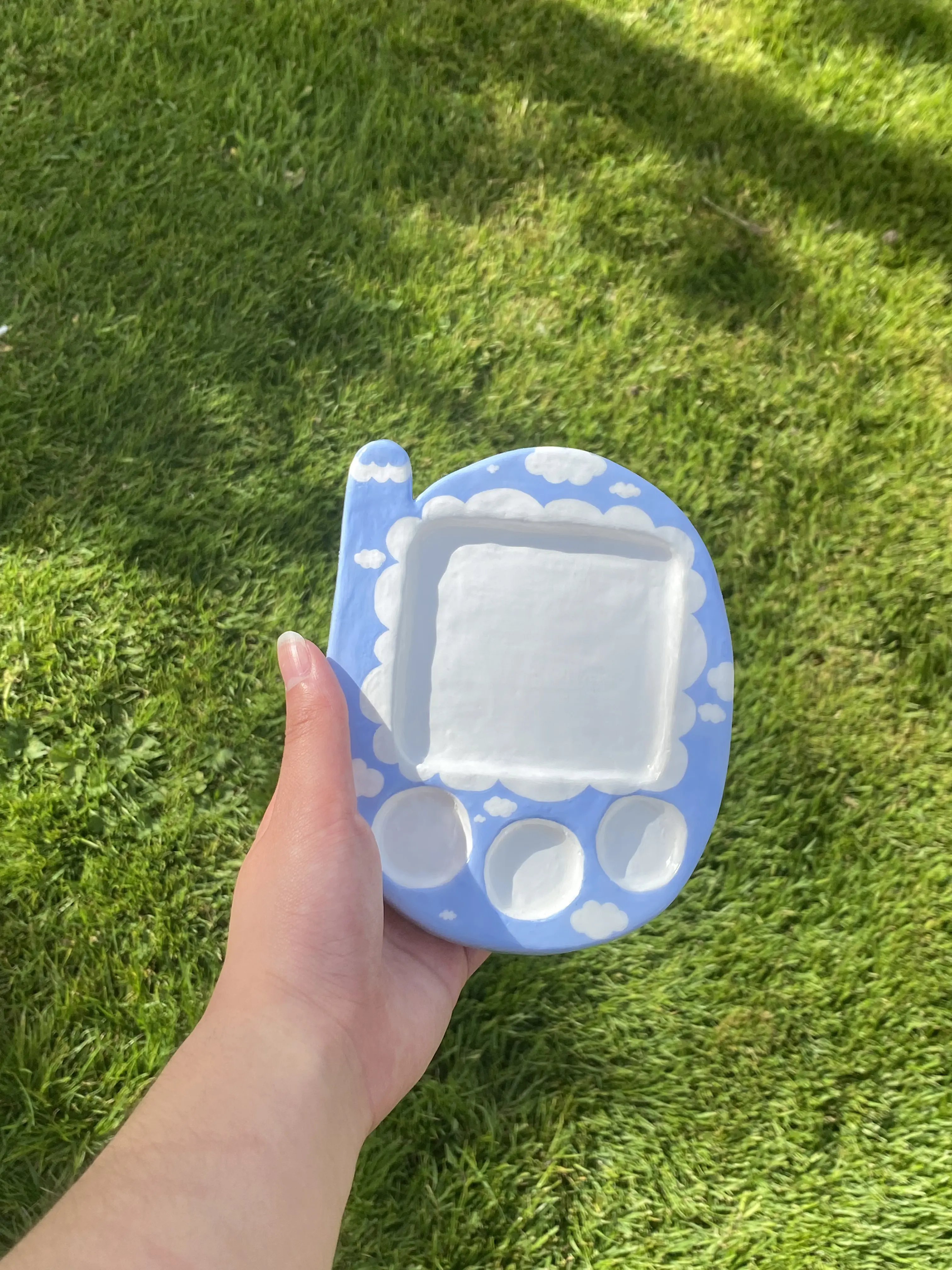 A photo of a sky blue tamagotchi trinket dish with white clouds