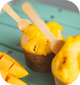 mango icecream in cup with spoon sticking out