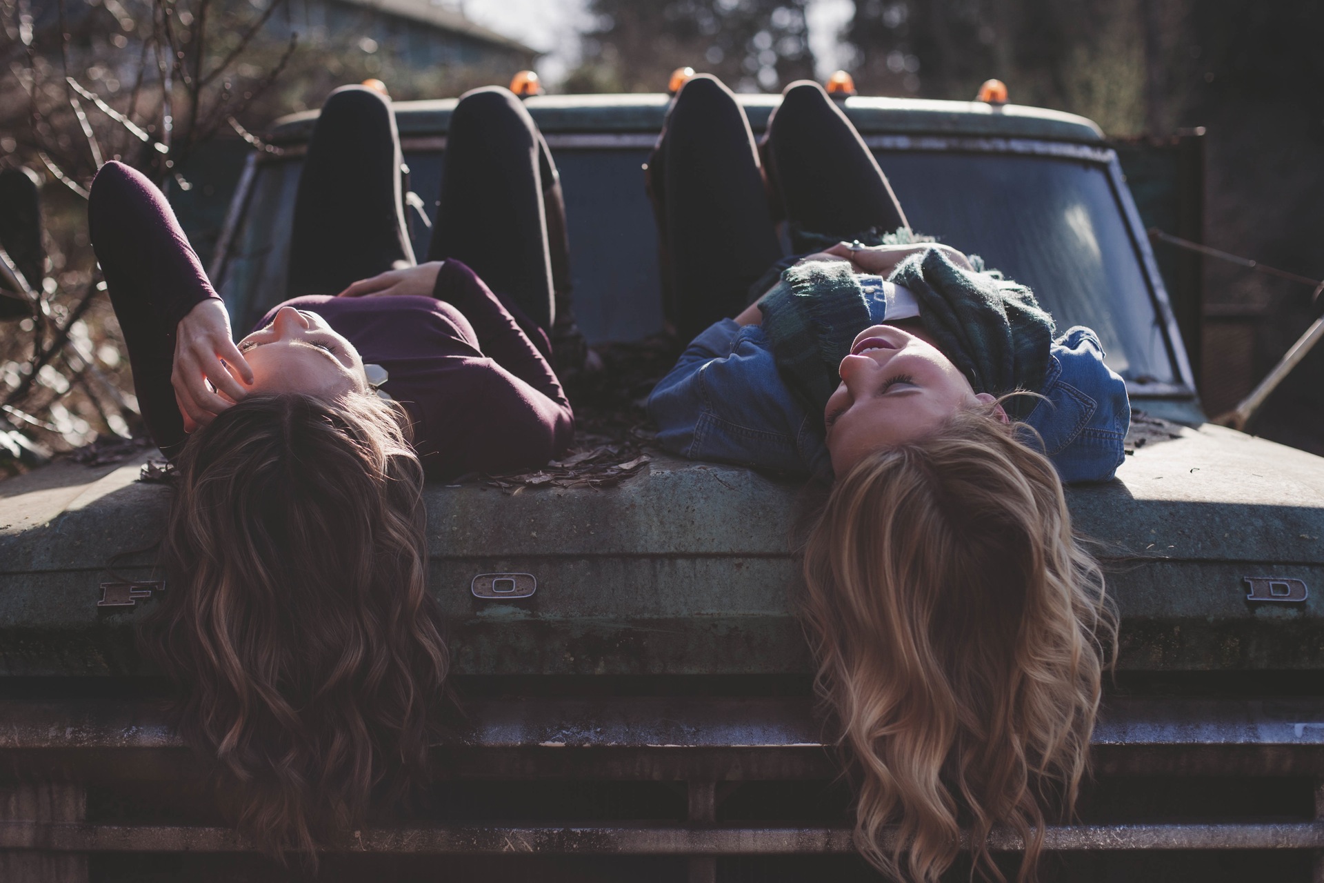 two girls talking on a car