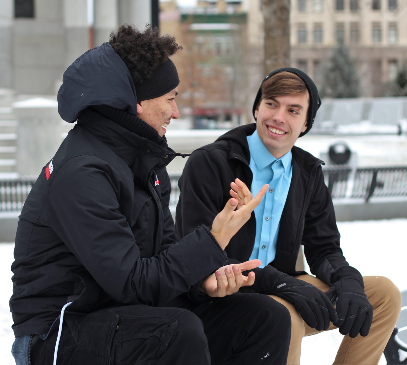 two guys sitting and talking on a winter day