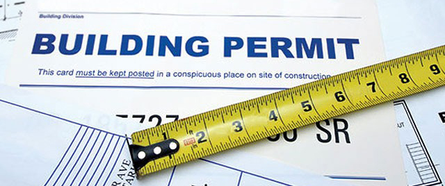 a piece of paper that says building permit with a tape measure